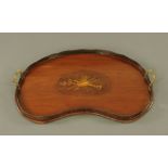 An Edwardian mahogany kidney shaped tray, inlaid to centre with musical tributes,