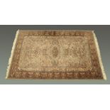 A Persian design woollen fringed carpet, principal colours beige, blue and green,