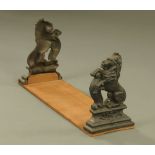 A Victorian and later book trough formed from a pair of cast iron rampant lion door porters mounted