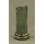 A green variegated marble cylindrical column on stepped octagonal base.