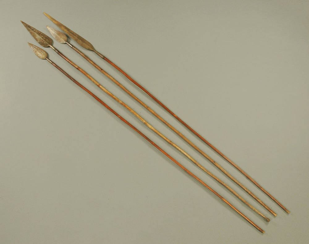 Four African spears, with steel blades and wooden shafts.