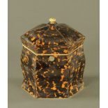 An early 19th century tortoiseshell hexagonal tea caddy, with ivory finial and shaped body.