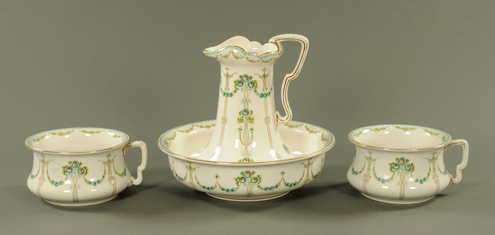 An Art Nouveau toilet jug, basin and two chamber pots, with stylised foliate pattern.