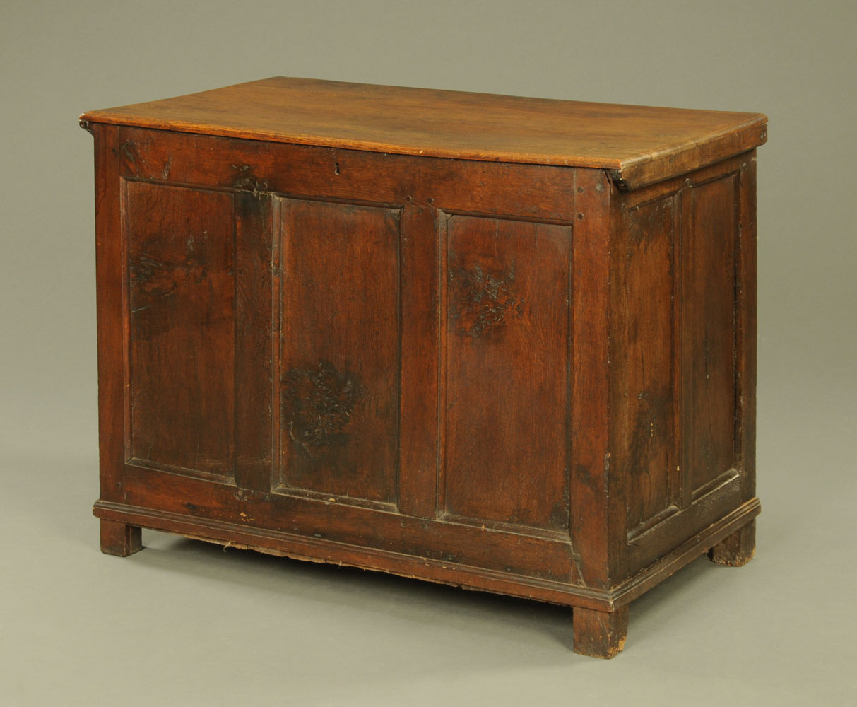 An 18th century panelled oak coffer, with later lid and three panelled front, on stile feet.