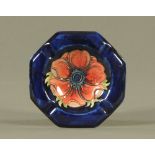 A Moorcroft tube lined pottery "Anemone" octagonal ashtray, decorated on a royal blue ground.