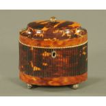 A George III tortoiseshell oval tea caddy, with ball finial and reeded sides.