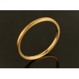 A 9 ct gold engine turned bangle, hollow, large, internal diameter 76 mm, 10.4 grams.