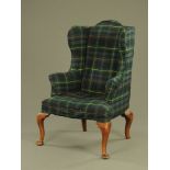 An 18th century oak wing chair, with cabriole front legs on padded feet,