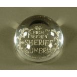 A domed clear glass paperweight, engraved " High Sheriff Cumbria March 1979-1980", 3.5 cm high x 7.