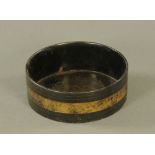 An early 19th century black papier mache cylindrical wine coaster, decorated with gilded band,