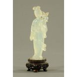 A Chinese carved jade figure of a standing woman, on rosewood stand, 17 cm high.