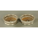 A pair of silver plated wine coasters, of gadrooned design, 5.5 cm high, 15 cm diameter.