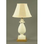 A white glazed porcelain pineapple shaped electric table lamp, on gilt base and with shade.