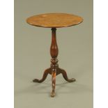A George III oak circular tripod table, on slender turned baluster column and splayed legs.