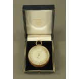 A large size ER Watts & Son London pocket aneroid barometer, brass cased with silvered dial.