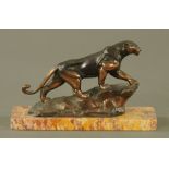 A cast metal patinated figure of a prowling Puma, raised on a marble base. Length 27.