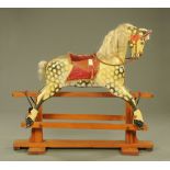 A late Victorian dapple grey rocking horse on pine safety stand. 137 cm high (see illustration).