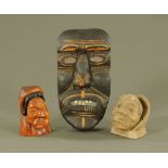 An Inuit carved wooden grotesque figural mask, and another cast figure. Tallest 30 cm.