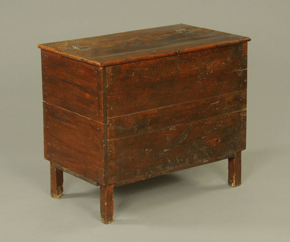 An 18th century oak and stained pine planked coffer or food bin with lifting top, on stile feet.