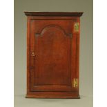 A George III oak wall cupboard,