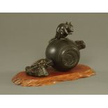 A 19th century Japanese bronze, depicting a rodent on top of a mallet, signed.