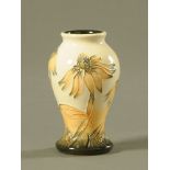 A Moorcroft tube lined pottery "Cornflower" pattern miniature vase.