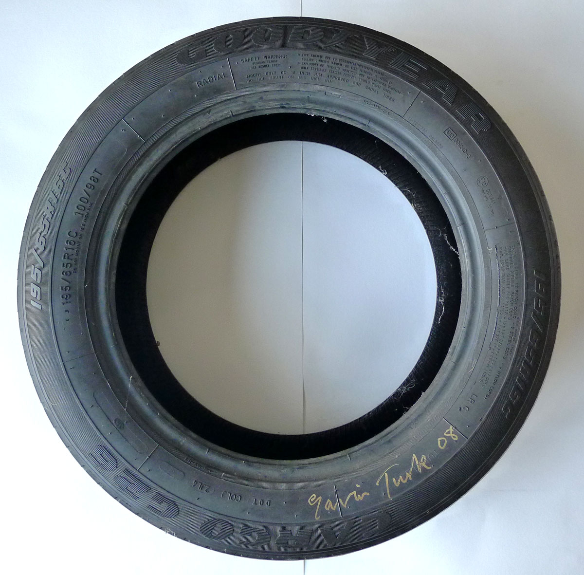 GAVIN TURK [b.1967]. Wheel Tyre, 2008. Used car tyre, signed and dated '08 in gold ink, from the