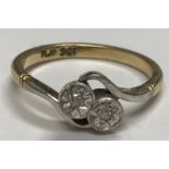 A 9 carat gold and platinum mounted ladies crossover dress ring set with two illusion set diamonds