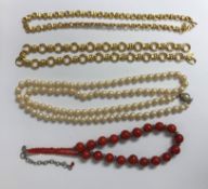 A Middle Eastern coral-coloured glass bead necklace, 45cm long overall,