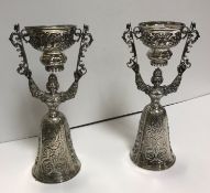 A pair of George V silver wager or wedding cups as a figure in mediaeval dress holding aloft a cup