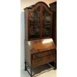 An early 20th Century walnut veneered bureau bookcase in the 18th Century style,
