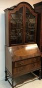 An early 20th Century walnut veneered bureau bookcase in the 18th Century style,