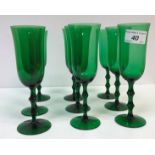 A set of eighteen green glass flutes on double knop stems to circular foot, 18.