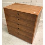 A 1960's yew wood chest of five long graduated drawers with brass flush handles,