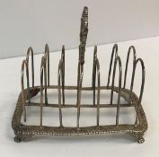 A late George III silver six section toast rack, the foliate decorated handle,