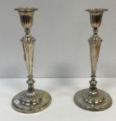 A near-matching pair of candlesticks in the Regency style with fluted decoration,