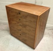 A 1960's yew wood chest of five long graduated drawers with brass flush handles,