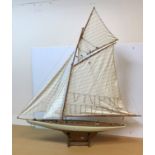 A modern scale model of a single masted sea going yacht on a purpose built wooden stand, 114.