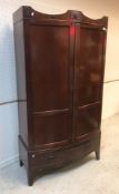 An Edwardian mahogany bow fronted two door wardrobe with single drawer on bracket feet,