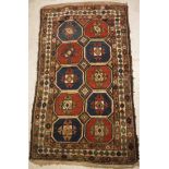 A Caucasian rug, the central panel set with repeating tiled decoration on a brown ground,