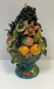 A Rosie Jackson pottery table centre heavily laden bowl of exotic fruits, the bowl with relief work,