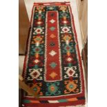 A Caucasian rug, the central panel set with two joined diamond medallions on a blue ground,