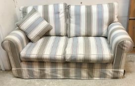 A modern upholstered two seater scroll arm sofa with cream, blue, grey and red striped loose covers,
