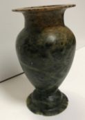 An Egyptian hand-carved soapstone vase of urn form with flared rim, raised on a turned ogee foot,