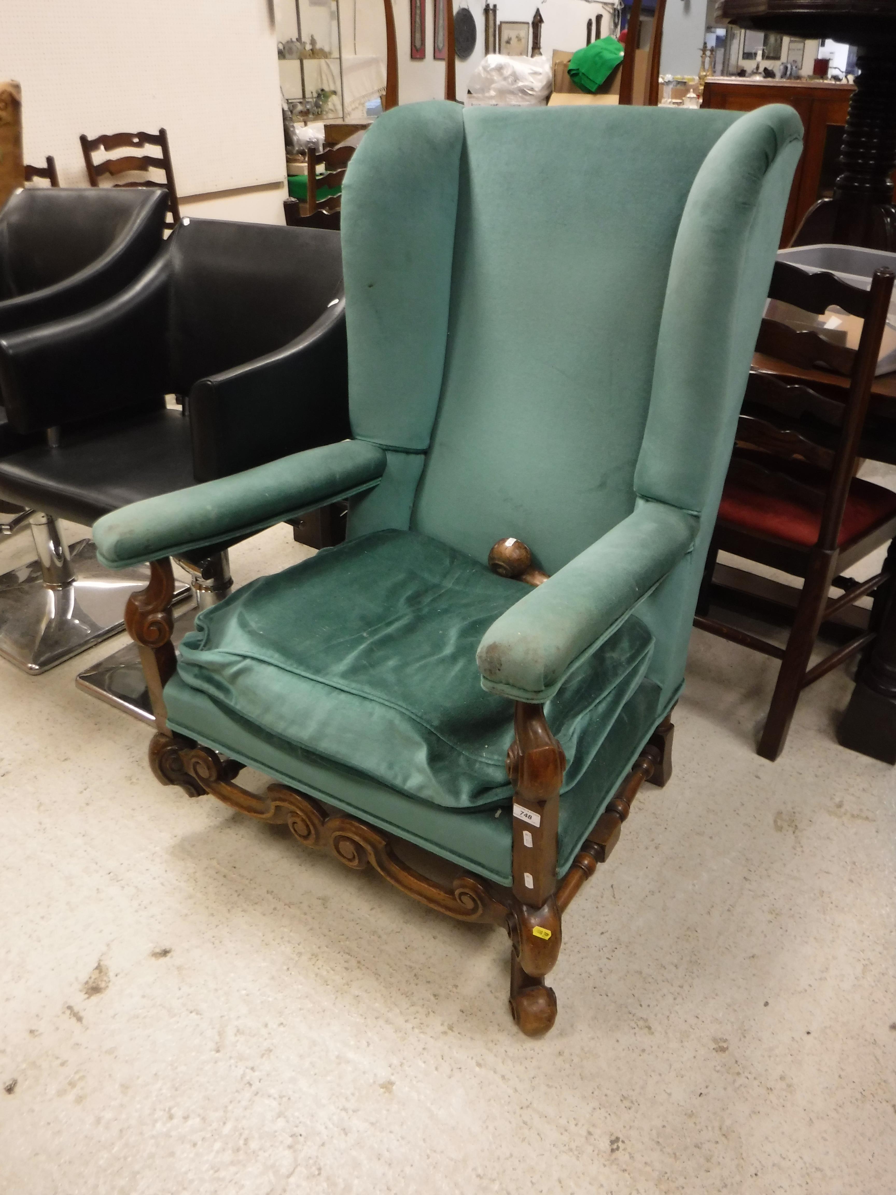 A circa 1900 upholstered wing back scroll armchair in the Flemish taste,