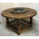 An oak circular occasional with integeral brass twin handled bowl to centre,