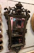 A 20th Century giltwood and gesso wall mirror in the Rococo taste with mask and gryphon decoration,