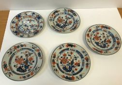 A set of four 19th Century Chinese Imari plates, each depicting a vase of flowers on a table,
