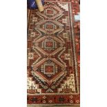 A fine Belouch tribal rug, the central panel set with repeating medallions on an orange,