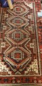 A fine Belouch tribal rug, the central panel set with repeating medallions on an orange,